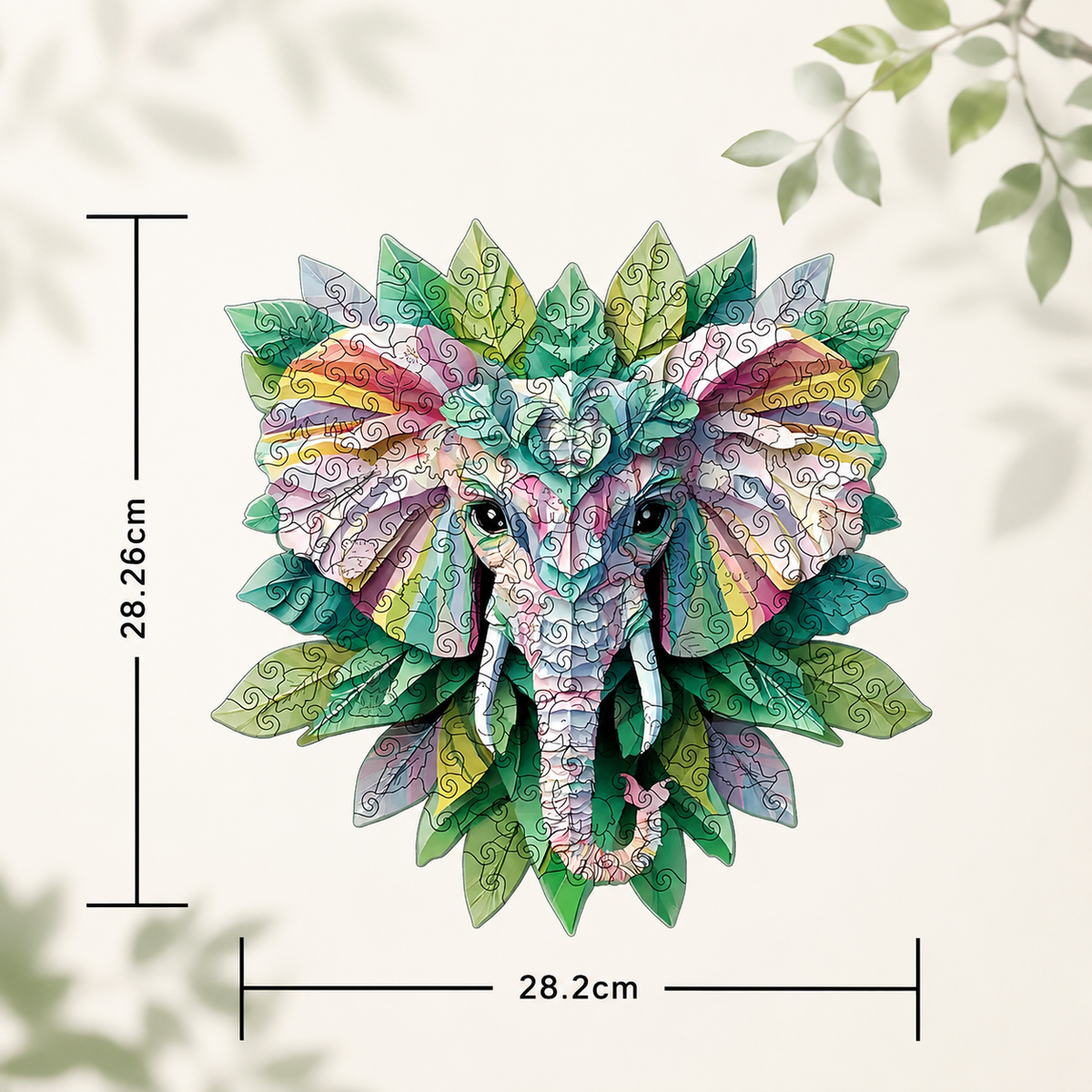 A colorful elephant head wall art piece surrounded by illustrated leaves, shown on a light cream background with measurement lines indicating 28.2 cm width and 28.
