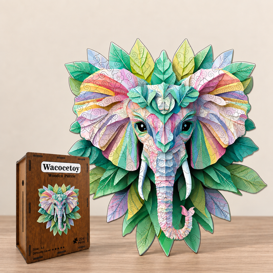A colorful assembled 3D elephant head puzzle with layered leaves and pastel patterned details, displayed beside its wooden box labeled 'Wacocetoy' on a light wood surface against a beige wall.